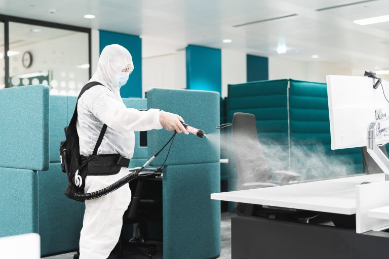 Person spraying a computer desk.